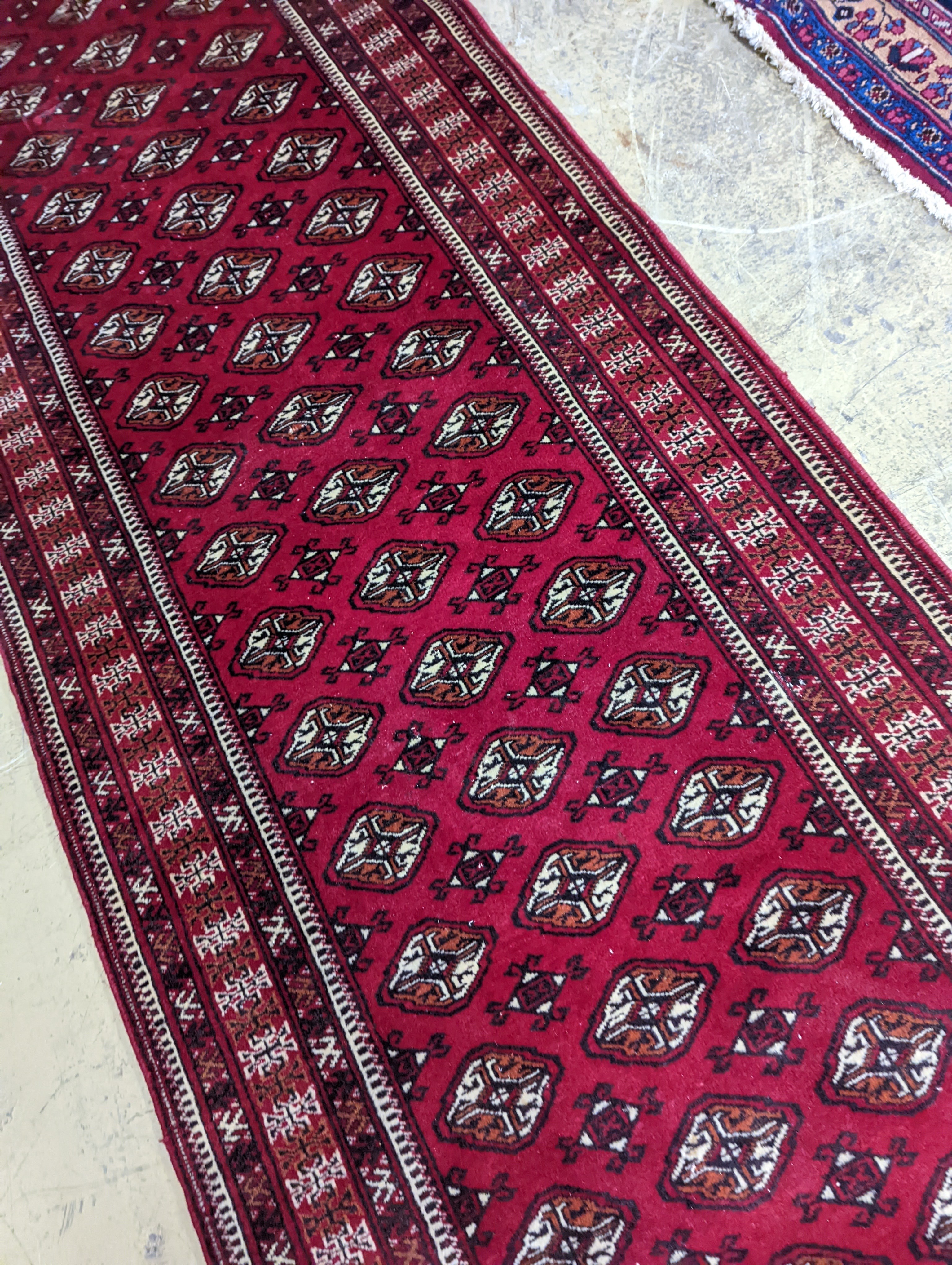 A Bokhara red ground runner, 364 x 98cm